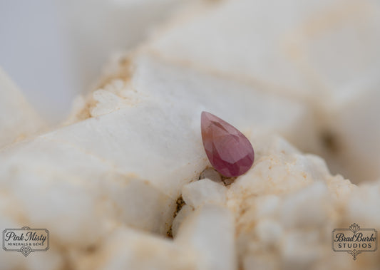 Pear shaped pinkish orange sapphire